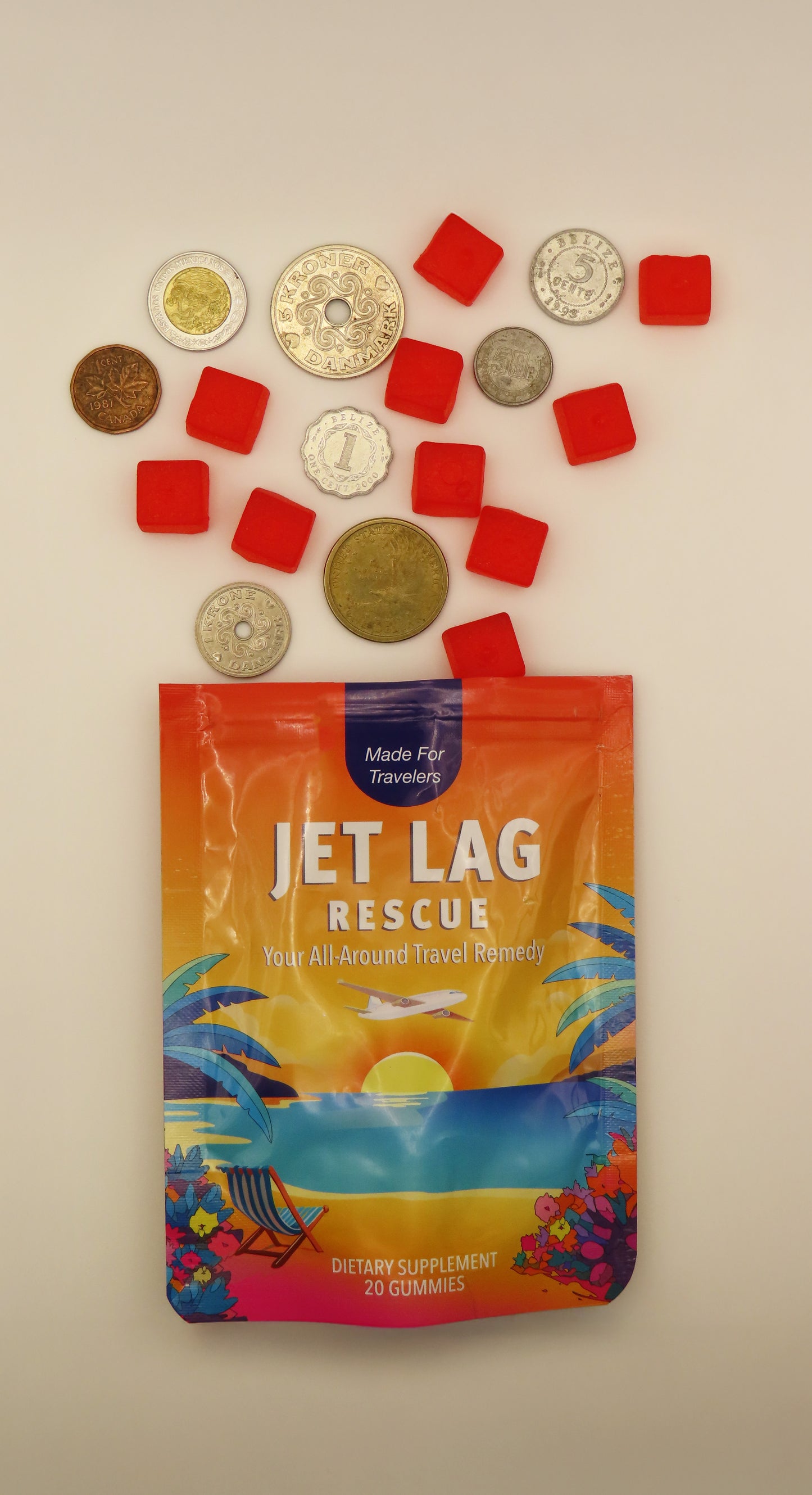Packaged product labeled 'Jet Lag Rescue' with foreign currency and gummy cubes on a beige background